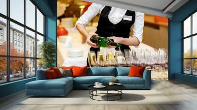 The waiter pours champagne in crystal glasses Wall mural