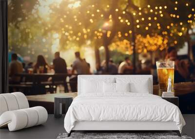 a cold drink and group of people, defocused, at a summer outdoor restaurant and bar, sunny warm lights and soft bokeh, during golden hour Wall mural