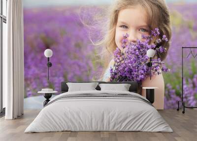 happy little girl in lavender field with bouquet Wall mural