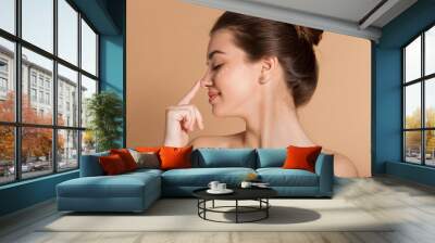 Happy smiling girl with perfect skin with moisturizing face cream on a cheek. Skin care and health concept. Wall mural