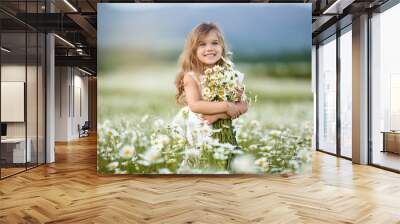 Little cute girl with bouquet of camomile flowers Wall mural