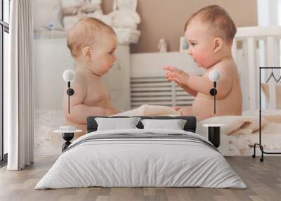 Two cute babies boy and girl are playing on bed Wall mural