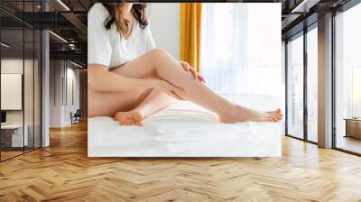 Female feet close-up. Woman massages and shows her beautiful smooth legs. Concept of laser epilation and varicosity Wall mural