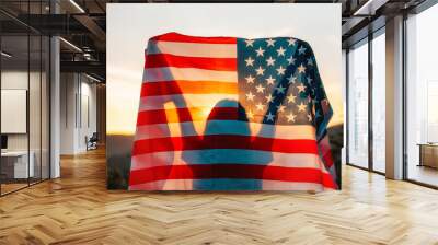 Independence day. Silhouette of woman holds an American flag in her hands, raised above her head. Back view. In the background, sunset and mountains. The concept of American National Holidays Wall mural