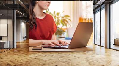 Remote work. Young beautiful Caucasian woman typing on a laptop. Concept of quarantine, modern technologies and freelancing. Close up Wall mural