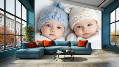 Adorable twins in matching knitted hats, cozy and calm Wall mural