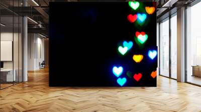 Multi colored blurred lights in the shape of hearts in the dark. Wall mural