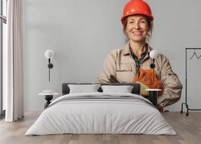 A confident woman in work gear smiles warmly, demonstrating pride in her construction skills Wall mural