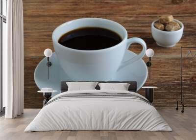 White porcelain cup and saucer with black coffee and cane brown sugar on wooden table Wall mural