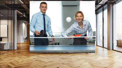 Business man and woman are playing together in table tennis. Play in the team. Office games during a working break. Wall mural