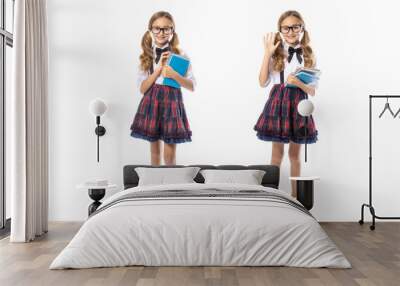 Schoolgirl girl in glasses and with textbook, standing full-length, isolated on white background. Two options one girl. Wall mural