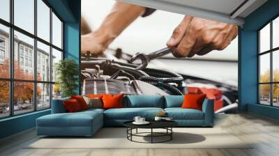 Automobile mechanic repairman hands repairing a car engine automotive workshop with a wrench, car service and maintenance,Repair service. Wall mural