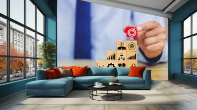 Hand of busines hold a target with arrow,stacking wooden blocks into steps,Concept of business growth success Wall mural