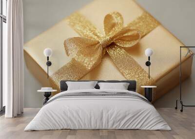 Elegant golden gift box tied with a shimmering ribbon, perfect for celebrations and special occasions. Wall mural