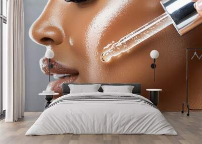 Woman applying serum to her face, highlighting skincare routine. Wall mural