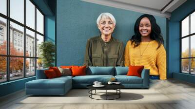 Happy, diversity and portrait of women on a blue background for success, happiness and work. Smile, business and a young and senior employee standing on a wall for a professional career profile Wall mural