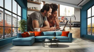 Laptop, couple and financial planning in a kitchen with documents for budget, savings and paying bills. Interracial, online and people with paperwork for taxes, mortgage and home loan application Wall mural