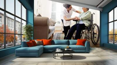 The best care you could hope for. Shot of a smiling caregiver helping a senior woman in a wheelchair at home. Wall mural