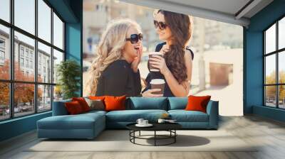 Lifestyle portrait of two best friends girls spending time in the center of the city at nice summer day, trendy fashion looks Wall mural