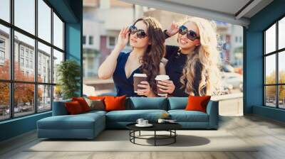 Lifestyle portrait of two best friends girls spending time in the center of the city at nice summer day, trendy fashion looks Wall mural