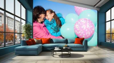 Mom and daughter posing on the beach in autumn with a balloons Wall mural