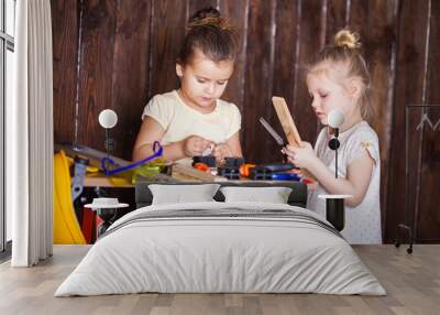 Two little girls making very interesting creations with tools and wood at home Wall mural