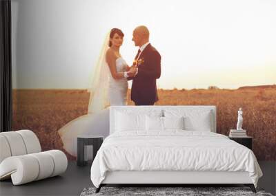 Young couple in love bride and groom on sunset background Wall mural