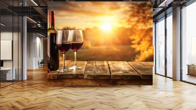 A Bottle of Red Wine and Two Glasses Resting on a Rustic Wooden Table, Set Against a Backdrop of a Golden Sunset and Autumnal Foliage Wall mural