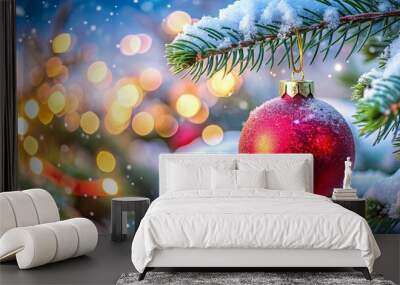 Closeup of red Christmas ornament on tree with lights and snow dusting Wall mural