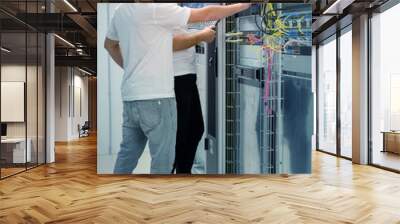 two IT professionals with notebook in server data center room solving a problem Wall mural