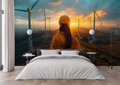 Wind turbine engineer. Male engineer maintains and controls wind turbine energy generation on the background of windmills. Concept of sustainable future. Wall mural