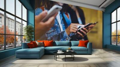 Bloggers together pointing finger on screen smartphone on background bokeh light in night atmospheric city, group adult hipsters friends using in hands mobile phone, online wi-fi internet concept Wall mural