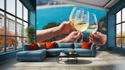 Drink glasses white wine in hands outdoor seascape holidays, romantic couple toast with alcohol, people cheering fun vacation enjoying travel time together friendship love concept congratulations Wall mural