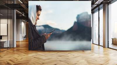 hipster tourist using smartphone planning trip on foggy lake, mist in mountain nature, traveler girl hold mobile phone, enjoy wifi internet, lifestyle holiday Wall mural