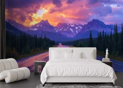 A quiet mountain highway with an asphalt surface, surrounded by towering peaks and a sky filled with vivid sunset colors Wall mural