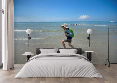 The boy runs to the sea at the beach cheerfully cheerful. On a clear day Wall mural