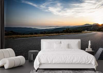 Empty long mountain road to the horizon on a sunny summer day at bright sunset Wall mural