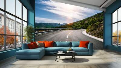 Empty long mountain road to the horizon on a sunny summer day at bright sunset Wall mural