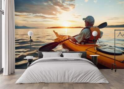 Elderly man in an oversized life jacket kayaking on the calm waters of Lake. Realistic golden hour lighting Wall mural