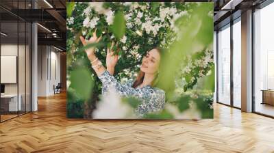 beautiful girl holding flowers. March 8: woman among flowers. the concept of congratulations, women's holidays, natural make up Wall mural