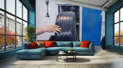 car repair: wheel replacement closeup. mechanic screwing or unscrewing car wheel at car service garage Wall mural