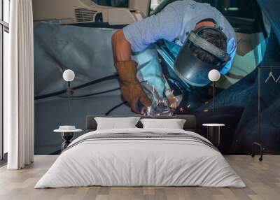 repair of the car interior. the man works with the welding in the trunk Wall mural