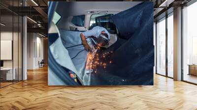 repair of the car interior. the man works with the welding in the trunk Wall mural