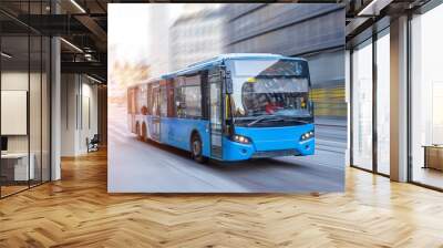 Blue bus moving on the road in city in early morning. Wall mural