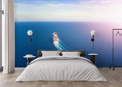 Cruise ship liner goes into horizon the blue sea leaving a plume on the surface of the water seascape during sunrise. Aerial view, concept of sea travel, cruises. Wall mural