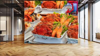 Large crabs and king prawns with green salad from dishes on a street food stall. Wall mural