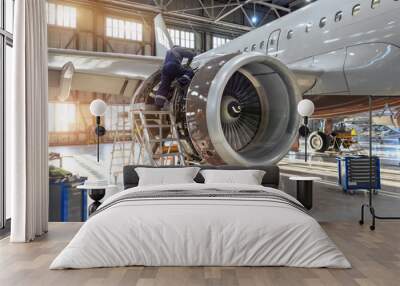 Mechanic specialist repairs the maintenance of engine of a passenger aircraft in a hangar Wall mural