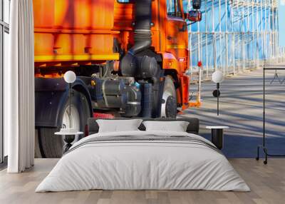 Orange cleaning truck with a brush vacuum cleaner for cleaning city streets. Wall mural