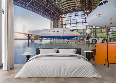 Passenger plane with a damaged engine is push roll up tow tractor to the hangar for repair, maintenance. Wall mural