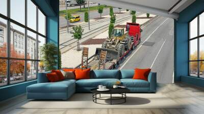 Tractor with bucket loaded on truck trailer, transportation aerial view. Wall mural